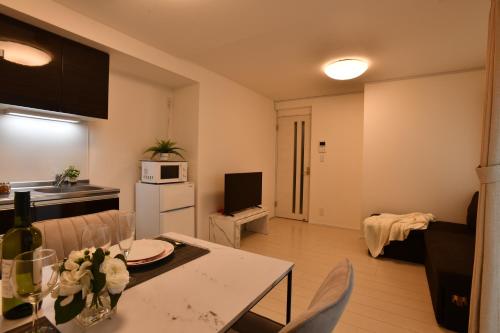 a kitchen and a living room with a table and chairs at FL Residence Todai II in Tokyo