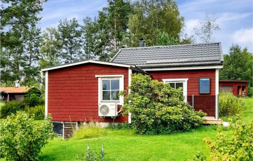 a small red house in a grassy yard at Awesome Home In Dalahusby With Kitchen in Dala Husby