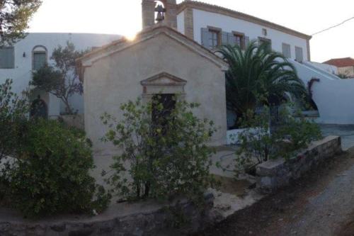 a small white building with a cross on top of it at Vranadika in Livadi