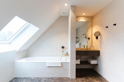 a bathroom with a sink, toilet and bathtub at Golden Tree Hotel in Bruges