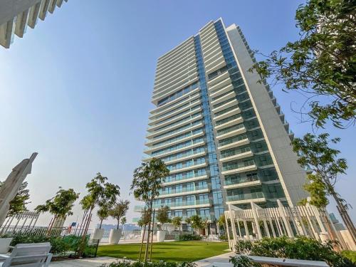 a tall building with trees in front of it at HiGuests - Superlative apt with private beach access in Dubai