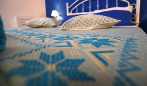 a bed with a blue and white bedspread and pillows at Casa Vacanza LiHele - Locazione Turistica in Castelsardo