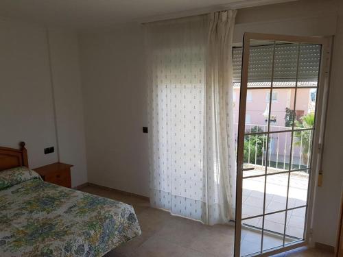 sypialnia z łóżkiem i przesuwnymi szklanymi drzwiami w obiekcie residencial nerea w mieście Peñíscola