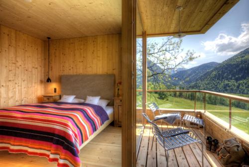 a bedroom with a bed and a balcony with a view at Tannerhof - Mein Versteck in den Bergen in Bayrischzell
