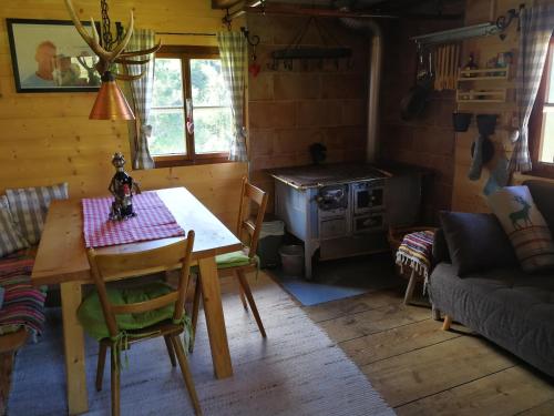 a dining room with a table and a stove at Almhütte Andrea in Wildschönau