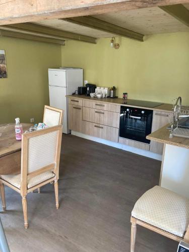 La cuisine est équipée d'une table, de deux chaises et d'un réfrigérateur. dans l'établissement Le carrosse, la diligence, centre Saint Jean de Losne tarif 2pers 1 chambre, tarif 4 pers 2 chambres, à Saint-Jean-de-Losne