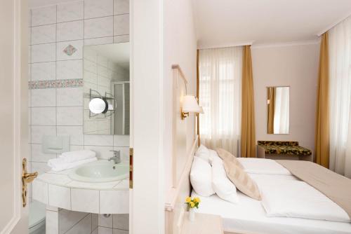a white bedroom with a bed and a sink at Villa Antonia in Bautzen