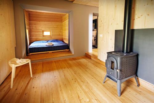 a bedroom with a bed and a wood stove at La Marmote Albergo Diffuso di Paluzza Faas in Paluzza