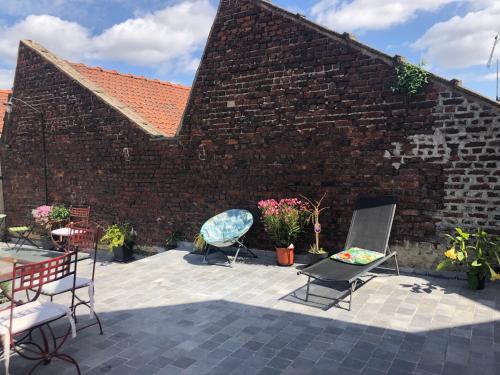 a patio with chairs and a brick wall at Loft atypique 192m2, terrasse, aux portes de Lille in Roubaix