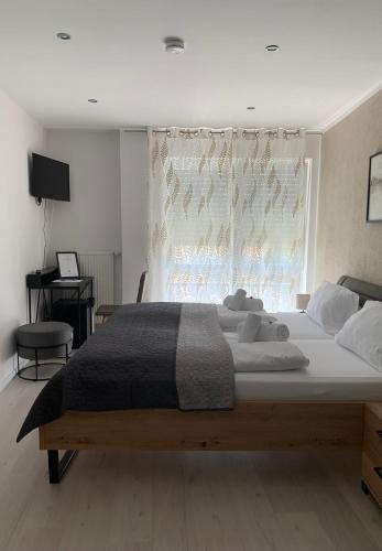 a large bed in a bedroom with a window at HGH - Hotel Garni Helbig in Neustadt an der Weinstraße