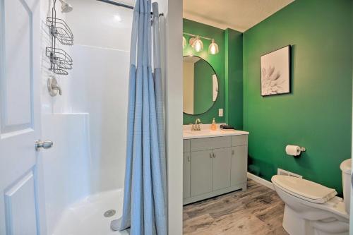 a green bathroom with a toilet and a shower at Coldwater Family Retreat with Boat Dock and Grill! in Coldwater