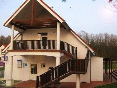a small white house with a balcony and stairs at Hotel Aeroplan in Zielona Góra