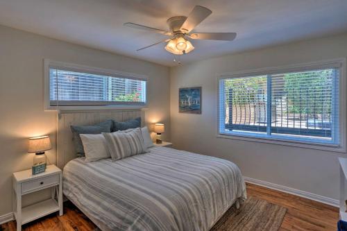 a bedroom with a bed with a ceiling fan and two windows at Orange County Gem Walk to Crescent Bay Beach in Laguna Beach