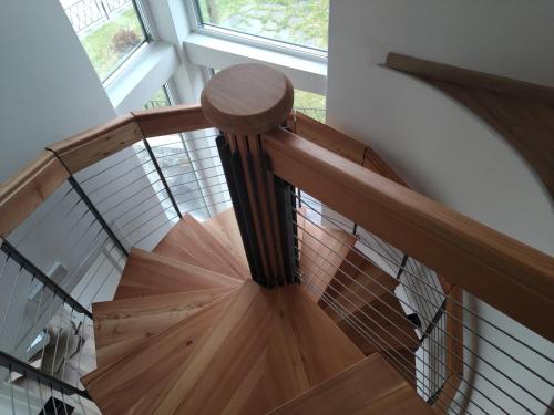 a wooden spiral staircase with a glass railing at Alpenrooms in Transacqua