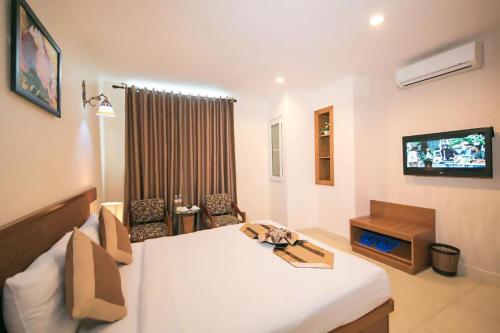 a hotel room with a bed and a television at Valentine Boutique hotel - 29 Bui Vien street in Ho Chi Minh City