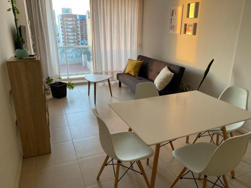 sala de estar con sofá, mesa y sillas en Departamento céntrico - Leer condiciones y precio en Río Cuarto