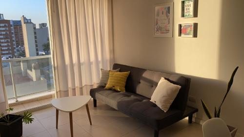 a living room with a couch and a window at Departamento céntrico - Leer condiciones y precio in Río Cuarto