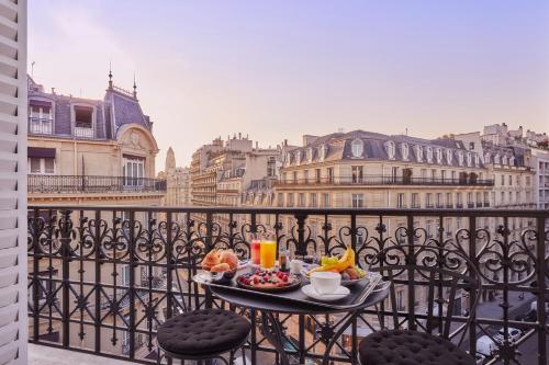 ein Tablett mit Speisen auf einem Tisch auf einem Balkon in der Unterkunft Grand Powers Hotel in Paris