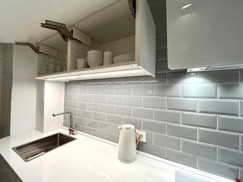a kitchen with a sink and blue tiles at 3 Zimmer Ferienwohnung Burghof mit Balkon im Herzen Flensburgs in Flensburg
