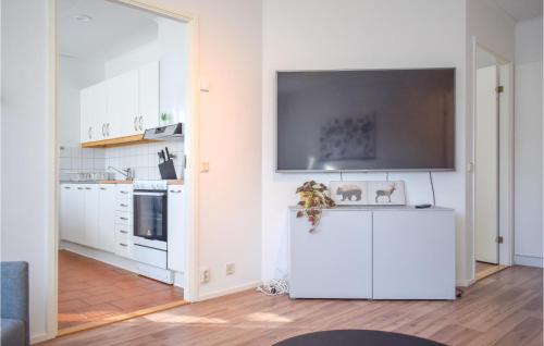 a white kitchen with a flat screen tv on the wall at Amazing Apartment In Påskallavik in Påskallavik