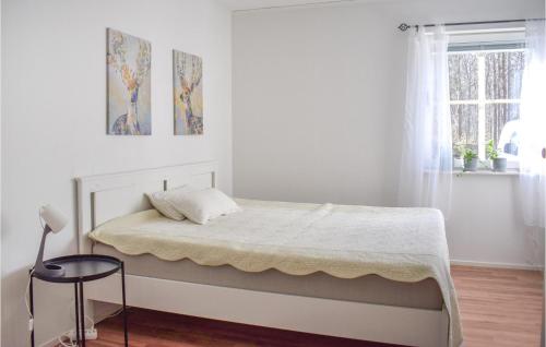 een bed in een witte kamer met een raam bij Amazing Apartment In Pskallavik With Wifi in Påskallavik