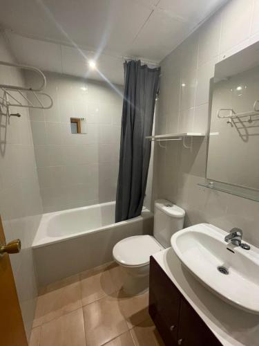 a bathroom with a white toilet and a sink at Appartement Vue Piscine-100 m de la plage in Empuriabrava