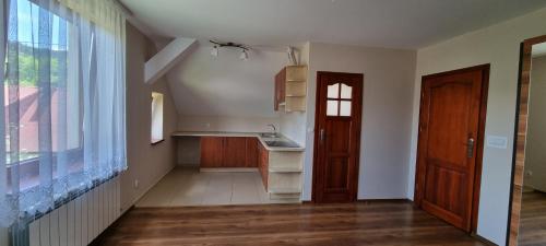 an empty kitchen with a sink and a door at Prywatny pokój z kuchnią i łazienką in Mszana Dolna