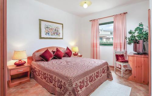 una camera da letto con un letto con cuscini rossi e una finestra di Quadri a Orosei