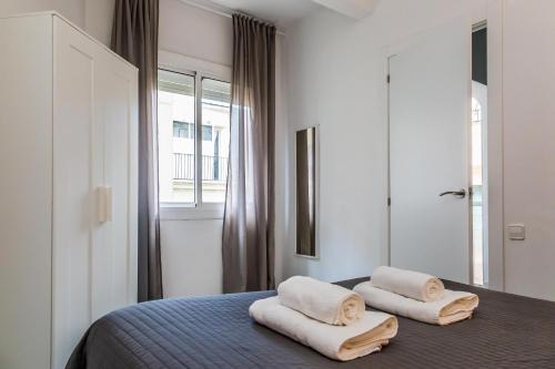 een slaapkamer met een bed met twee handdoeken erop bij Opening Doors Gràcia in Barcelona