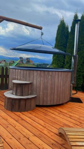 a wooden deck with a bench on top of it at Drevenička Anička - Liptovská Mara in Liptovský Trnovec