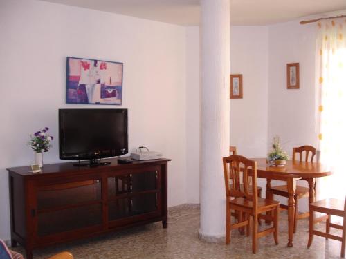 a living room with a tv and a table with chairs at Los Olivos - Zand Properties in Benidorm