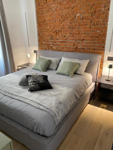 a large bed in a room with a brick wall at Junior Suite agli Archi in Torri del Benaco