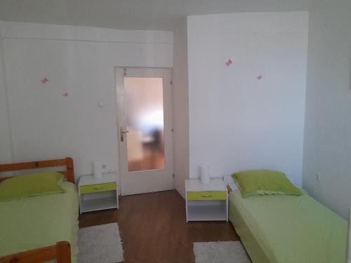 Habitación con 2 camas y puerta con espejo. en Apartment Maja, en Lovran