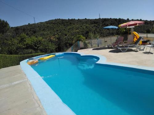 a large blue swimming pool with a table and chairs at MyStay - Quinta do Tendeiro in Guarda