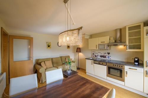 a kitchen and living room with a couch and a table at Waldvilla BERGSEE in Bodensdorf