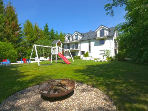 a backyard with a fire pit and a playground at Willa Liliowa in Dębki