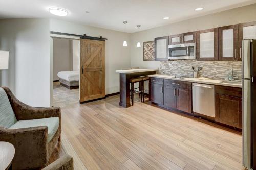 a large kitchen with wooden cabinets and a bed at Staybridge Suites Baltimore - Inner Harbor by IHG in Baltimore