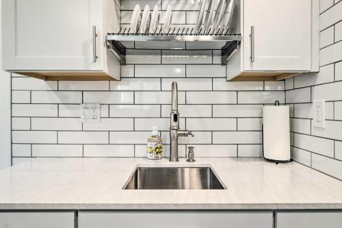 a kitchen with a sink and white tiled walls at Heart of Reno Studio about 1 Mi to Downtown! in Reno