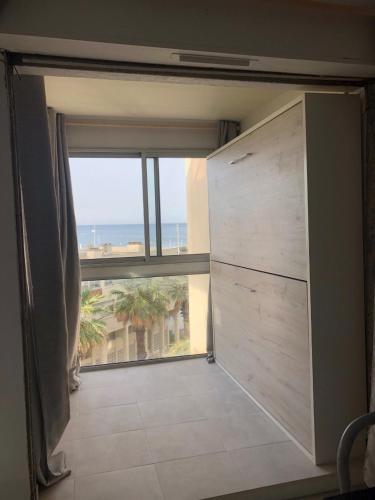 Cette chambre dispose d'une grande fenêtre et d'une grande porte. dans l'établissement T 1 VUE MER 180 D° TEMPLE DU SOLEIL, à La Grande Motte