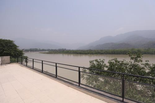 vistas a un río con montañas en el fondo en The Naga Rishikesh, en Rishīkesh