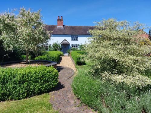 a house with a garden and a walkway at Beautiful 3 Bedroom Cottage - Picturesque Retreat in Lichfield