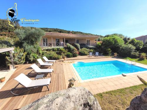une piscine avec des chaises et une maison dans l'établissement Villa 125m2 6/8 pers Trinité de Porto Vecchio Piscine, à Porto-Vecchio