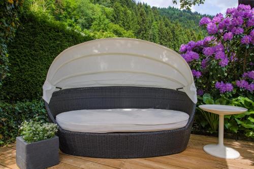 a chair sitting on a wooden deck with flowers at Waldvilla BERGSEE in Bodensdorf