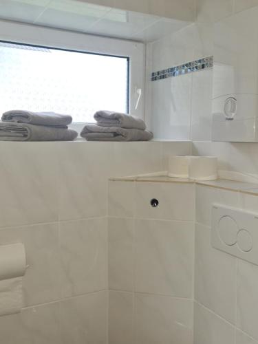 a white bathroom with a shower and a window at Gesamte Unterkunft free parking, WLAN in Niestetal