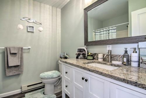 Un baño con lavabo, inodoro y espejo. en Near Ocean City Beach Waterfront Condo with Deck!, en Ocean City