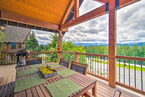a wooden deck with a table and chairs on a balcony at Pool Access Cle Elum Mtn-View Cabin with Game Room in Cle Elum
