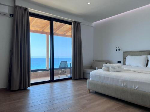 1 dormitorio con cama y vistas al océano en Hotel Juza, en Borsh