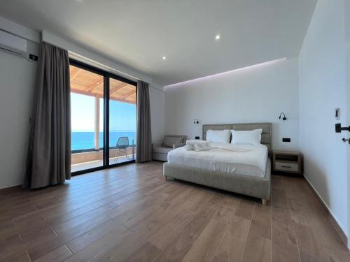 a bedroom with a bed and a view of the ocean at Hotel Juza in Borsh
