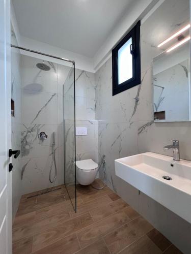 a bathroom with a glass shower and a sink at Hotel Juza in Borsh