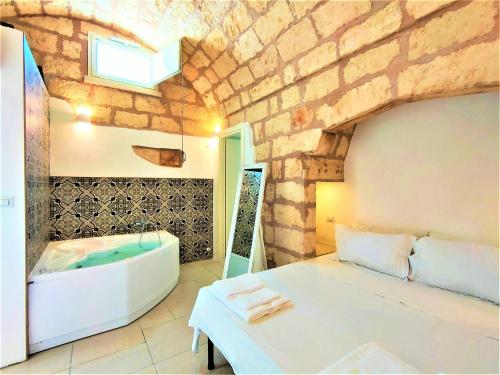 a bathroom with a tub and a bed and a sink at Da Lorenza di Casa Camilla Journey in Depressa
